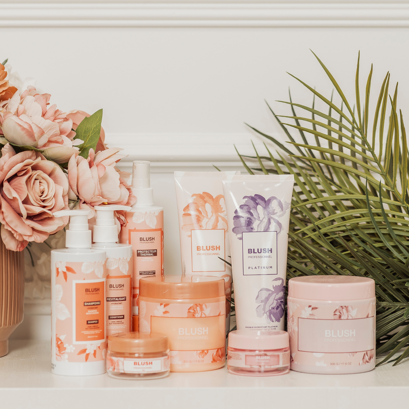 BLUSH Cure Absolue hair care bundle featuring shampoo, conditioner, heat protectant, and hair masks displayed with flowers and plants for a natural aesthetic