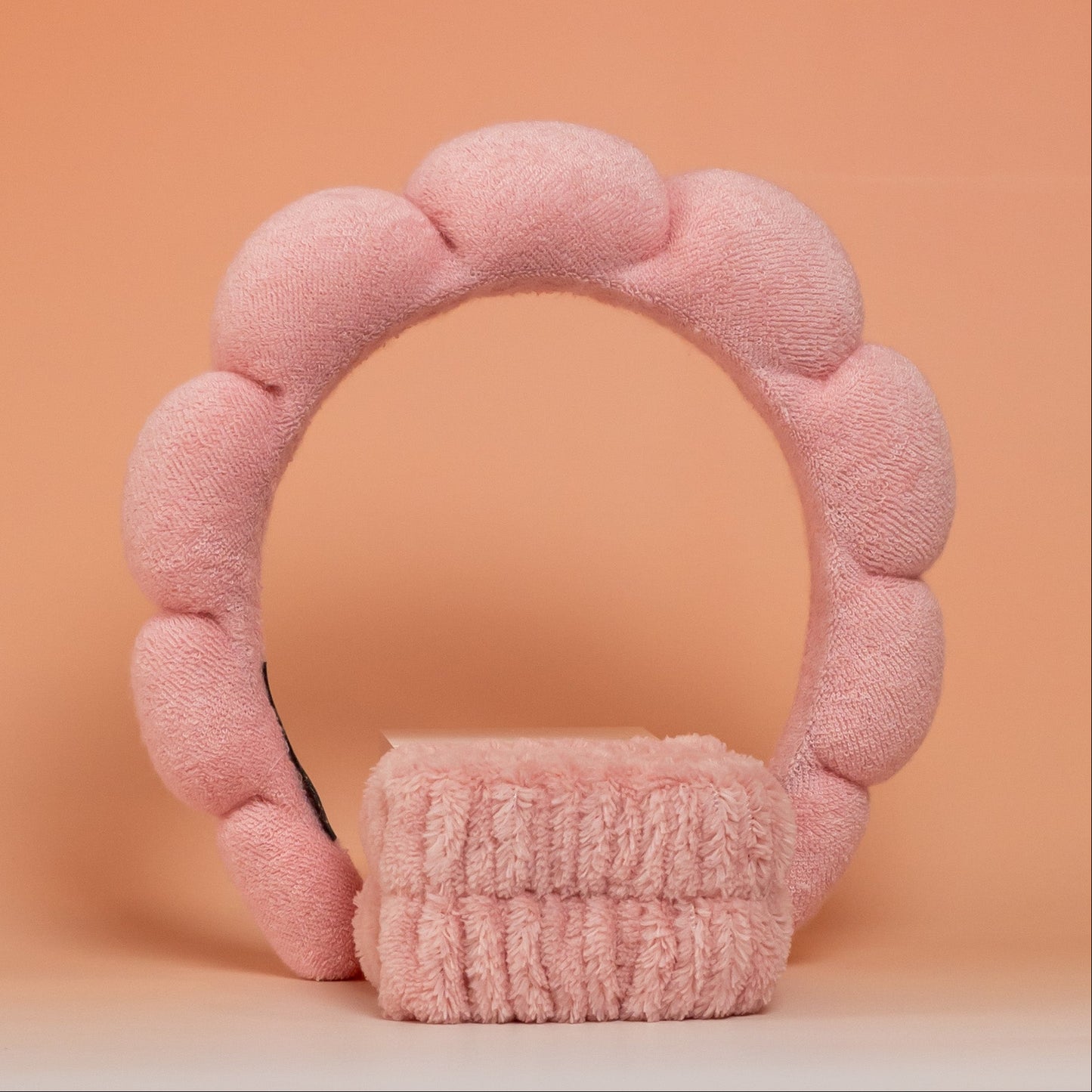 Coral BLUSH skincare headband and wristband set designed to keep hair dry and in place during skincare routines, with a soft, comfortable, and easy-to-clean texture