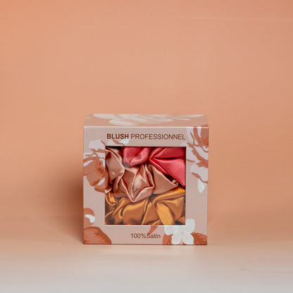 Orange BLUSH box containing a set of 3 satin scrunchies designed to help protect hair and reduce friction