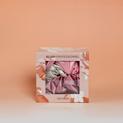 Pink BLUSH box containing a set of 3 satin scrunchies designed to help reduce hair breakage and friction