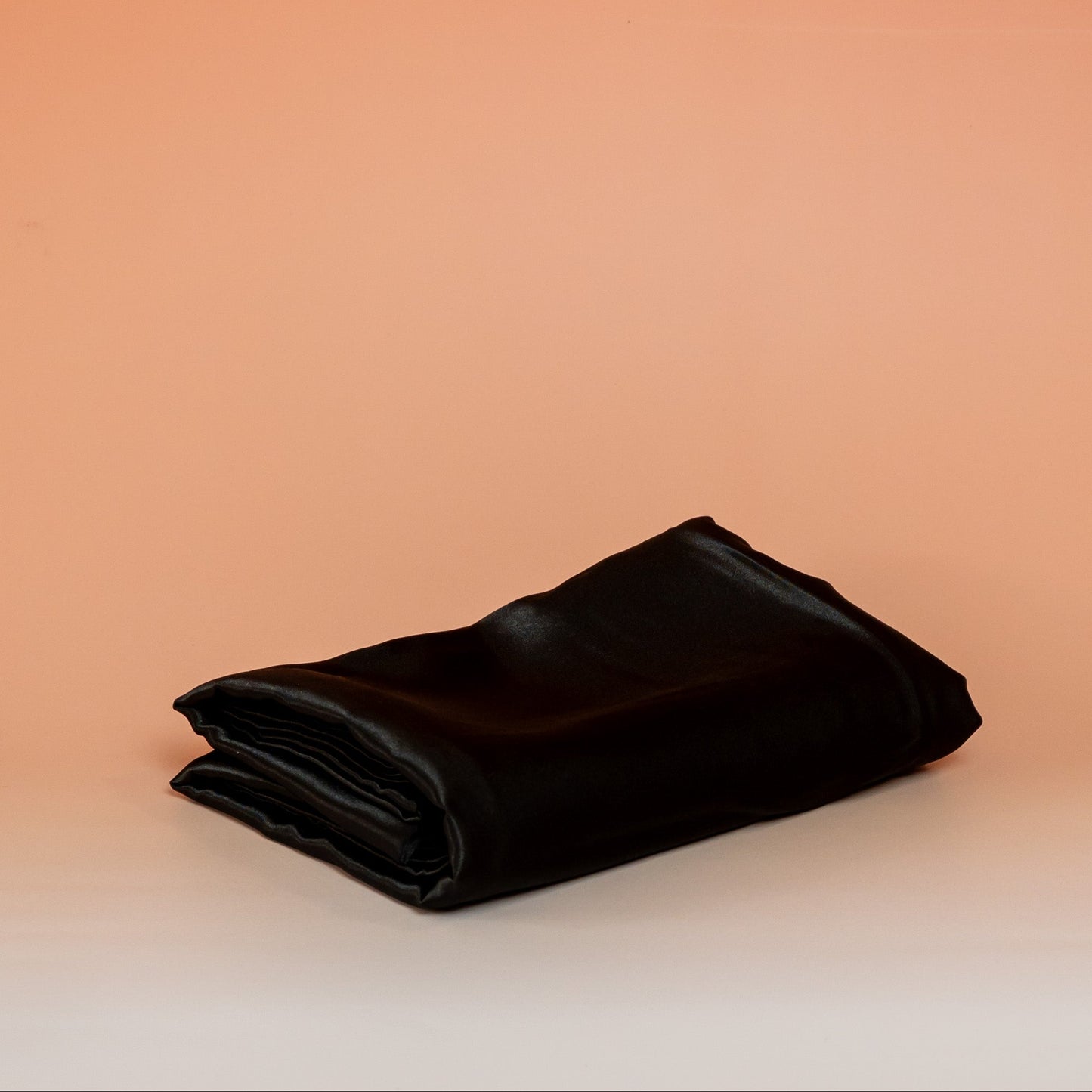 Black BLUSH satin pillowcase that helps reduce friction, protect hair and skin, and provide breathable comfort