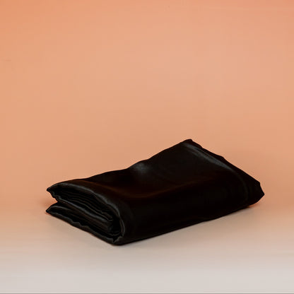 Black BLUSH satin pillowcase that helps reduce friction, protect hair and skin, and provide breathable comfort