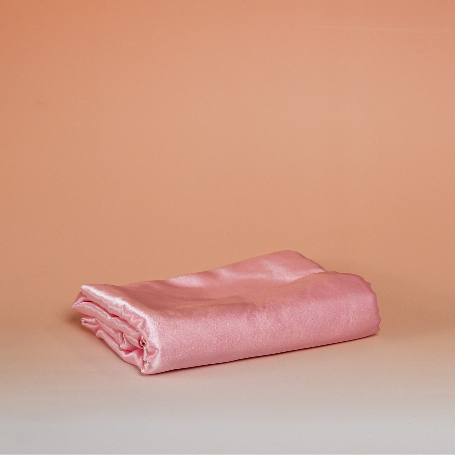 Dark pink BLUSH satin pillowcase that helps reduce friction, protect hair and skin, and provide breathable comfort.