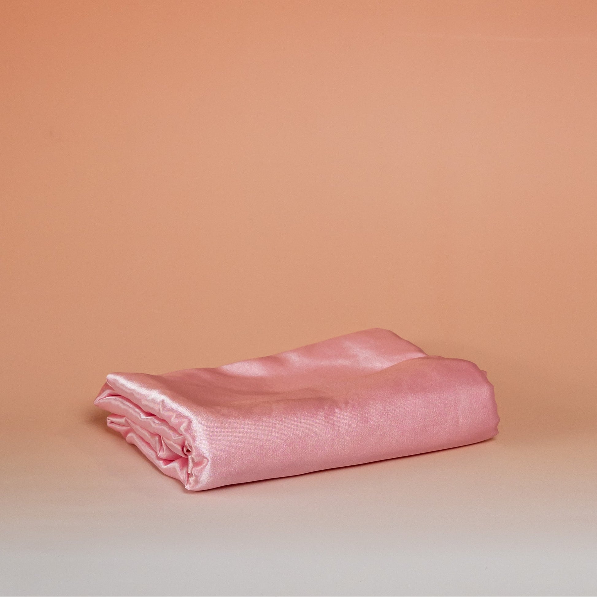 Dark pink BLUSH satin pillowcase that helps reduce friction, protect hair and skin, and provide breathable comfort.
