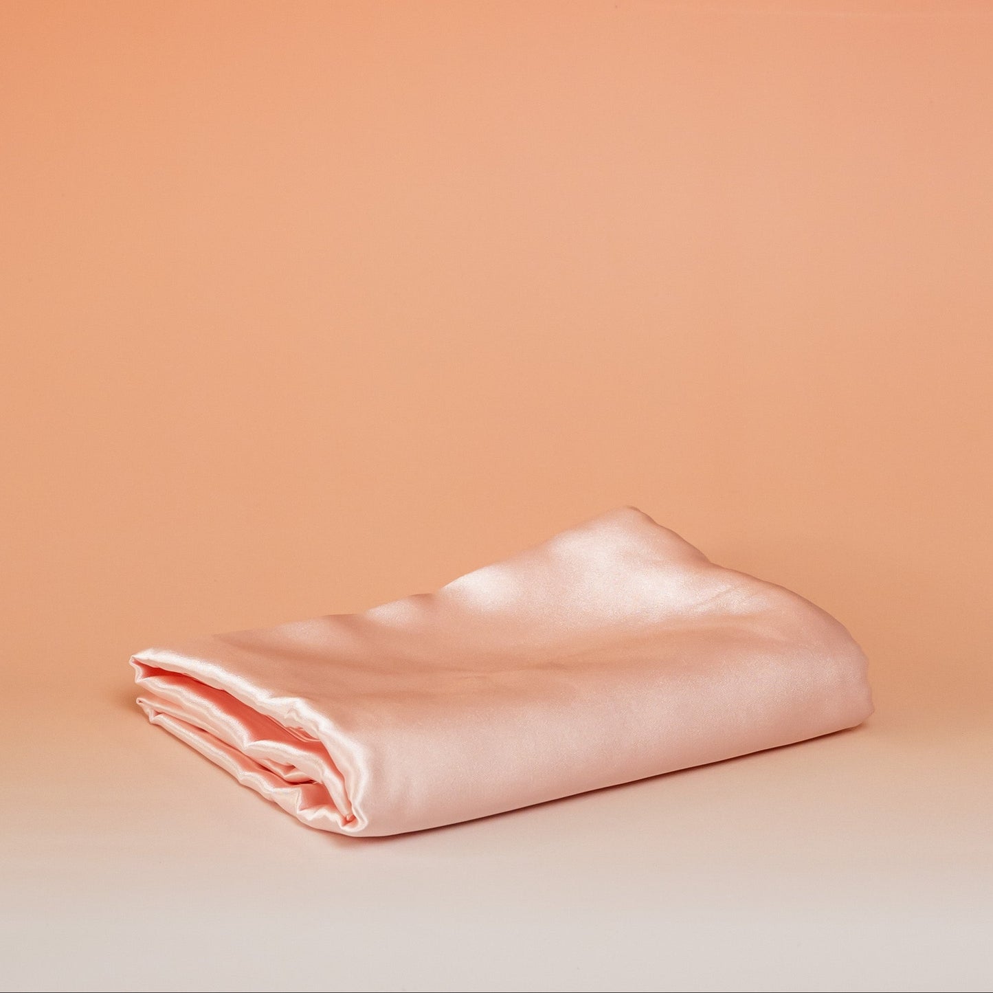 Light pink BLUSH satin pillowcase that helps reduce friction, protect hair and skin, and provide breathable comfort