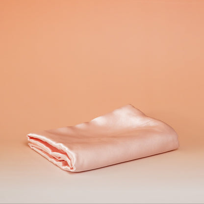 Light pink BLUSH satin pillowcase that helps reduce friction, protect hair and skin, and provide breathable comfort