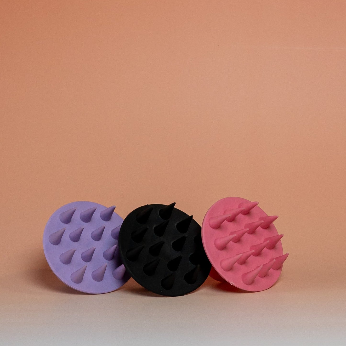 Collection of BLUSH silicone scalp scrubber brushes designed to massage the scalp, stimulate blood circulation, and support healthy hair growth