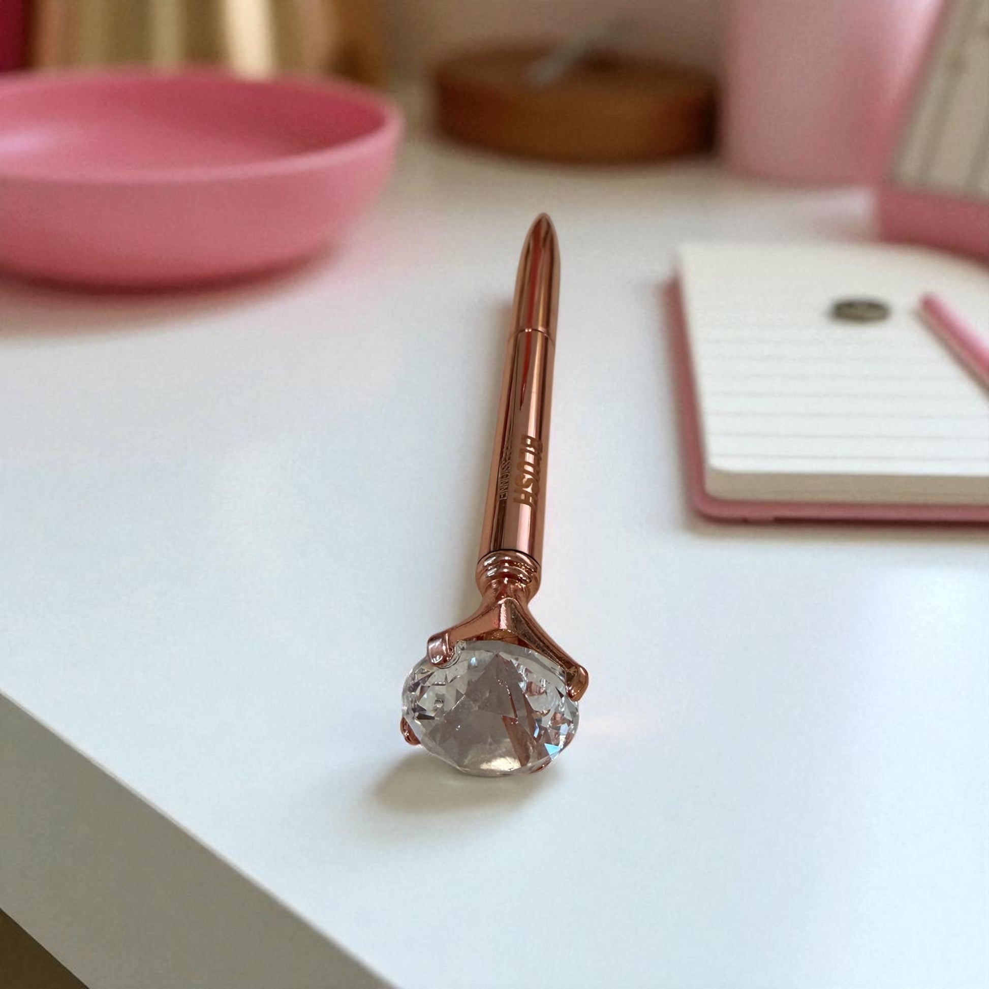 BLUSH signature diamond pen placed on a workspace desk, designed for smooth writing with black ink and an elegant crystal tip
